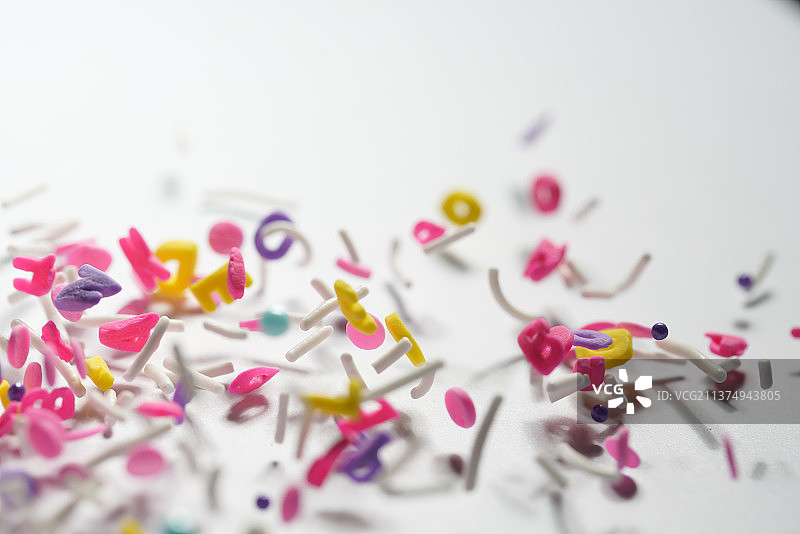 粉紫色黄蓝色各类糖果掉落在白色背景上棚拍创意图图片素材