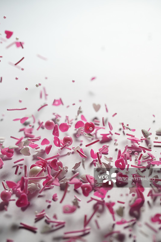 粉色系各类糖果掉落在白色背景上棚拍创意图图片素材