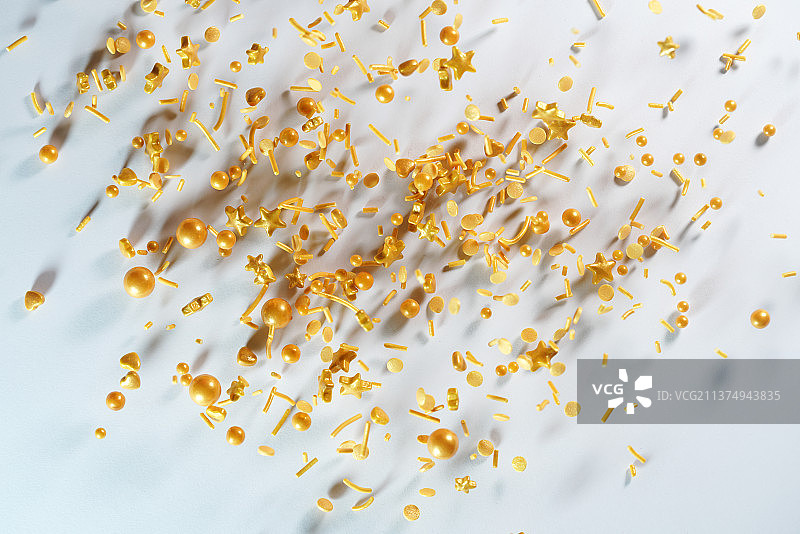 金色各类糖果掉落在白色背景上棚拍创意图图片素材