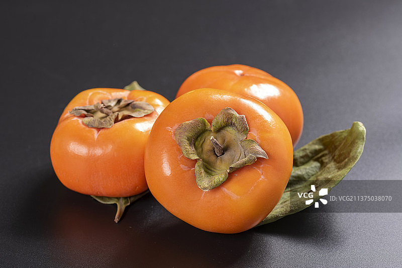 一盘柿子与切开色柿子特写中国风图片素材