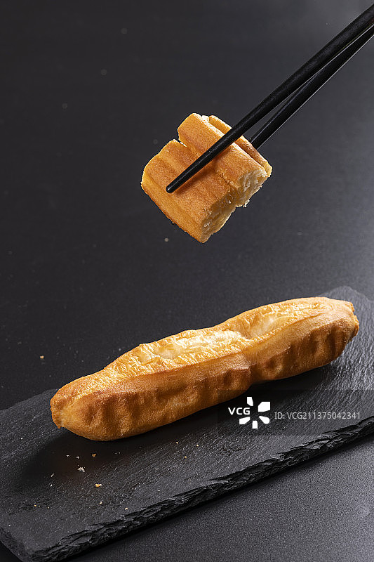 传统早餐一盘油条特写黑色背景图片素材