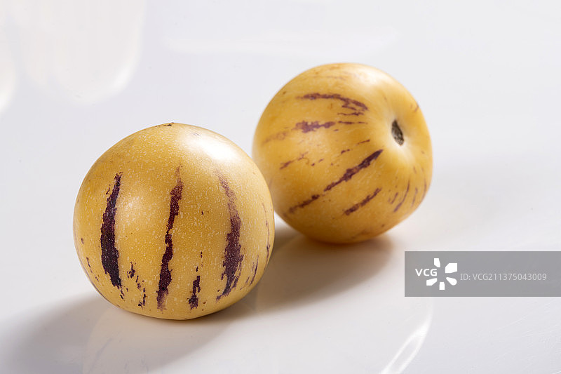 一盘人参果与切片人参果茶水摆放在桌面上特写图片素材