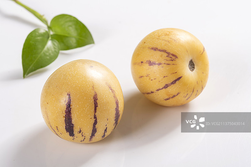 一盘人参果与切片人参果茶水摆放在桌面上特写图片素材