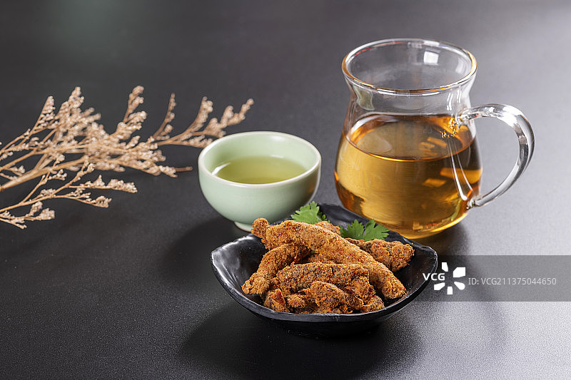 一盘麻辣牛肉干及调料摆放在桌面上特写图片素材