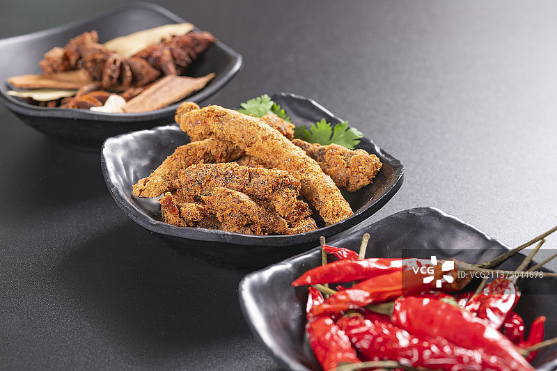 一盘麻辣牛肉干及调料摆放在桌面上特写图片素材