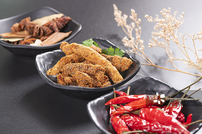 一盘麻辣牛肉干及调料摆放在桌面上特写图片素材