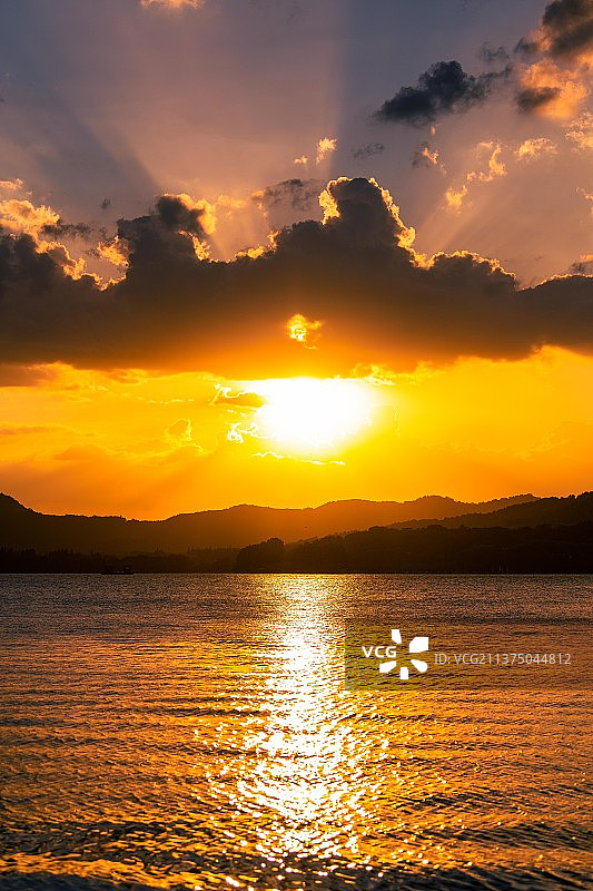 日落时浪漫的天空映衬下的杭州西湖图片素材