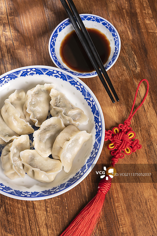 一盘水饺醋碟中国结摆放在桌面上特写图片素材