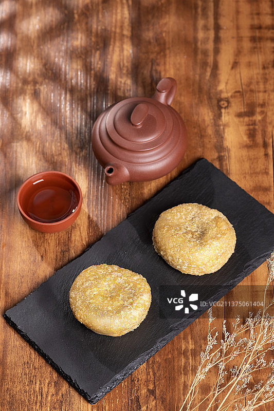 天津小吃炸糕与茶水摆放在木桌面上特写图片素材