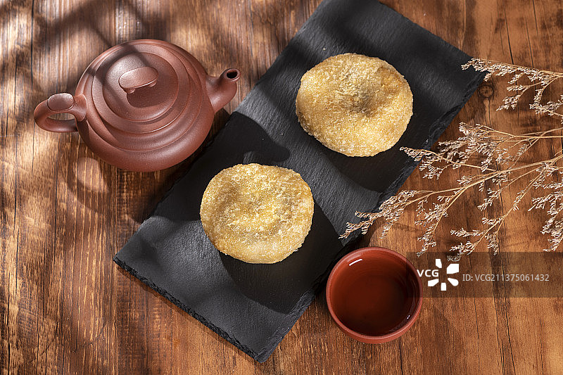 天津小吃炸糕与茶水摆放在木桌面上特写图片素材