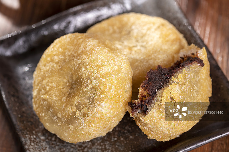 天津小吃炸糕与茶水摆放在木桌面上特写图片素材