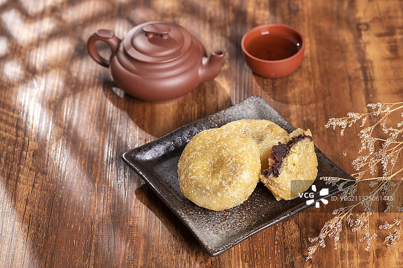 天津小吃炸糕与茶水摆放在木桌面上特写图片素材
