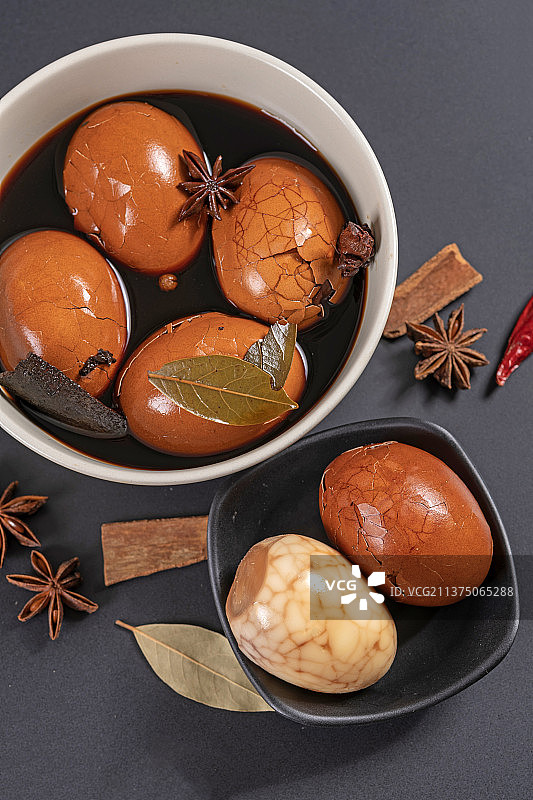 一盘茶叶蛋茶水香料摆放在黑色背景特写图片素材