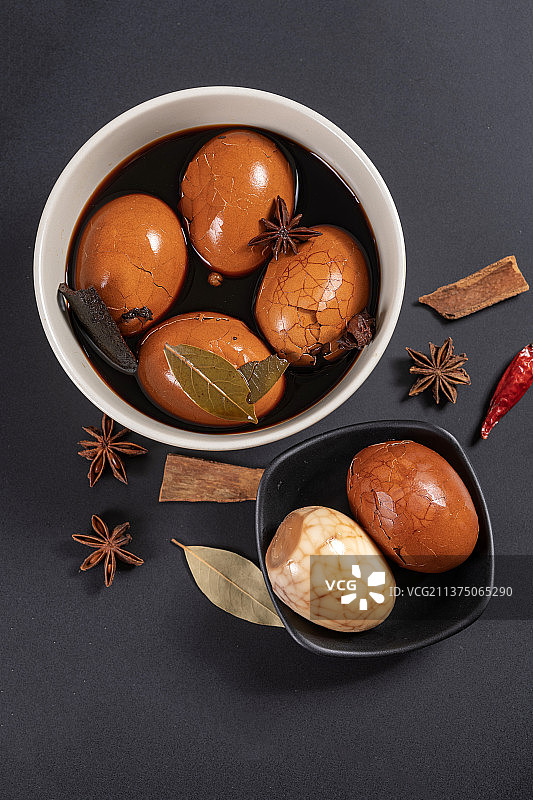 一盘茶叶蛋茶水香料摆放在黑色背景特写图片素材