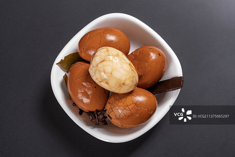 一盘茶叶蛋茶水香料摆放在黑色背景特写图片素材