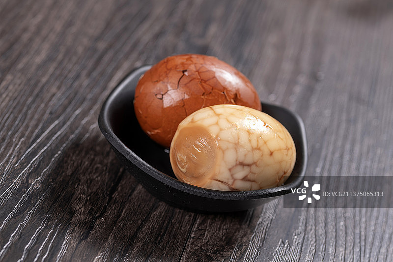 一盘茶叶蛋茶水香料摆放在黑色背景特写图片素材