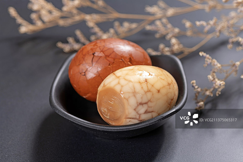 一盘茶叶蛋茶水香料摆放在黑色背景特写图片素材