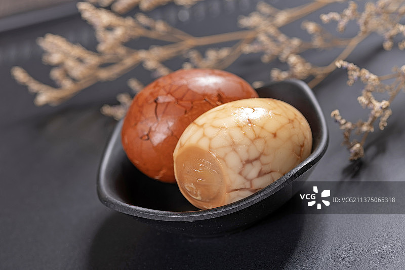 一盘茶叶蛋茶水香料摆放在黑色背景特写图片素材