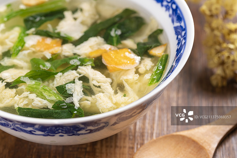 一碗菠菜蛋花汤和木勺特写图片素材