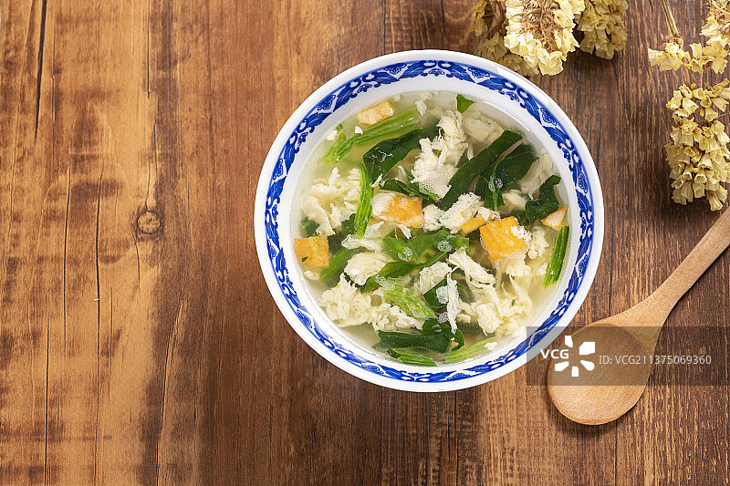 一碗菠菜蛋花汤和木勺特写图片素材