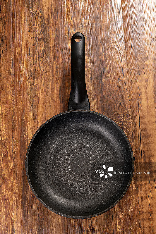 一把平底锅摆放在木桌面上图片素材