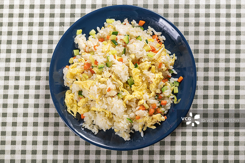 一盘鸡蛋炒米饭摆放在木桌面上特写图片素材