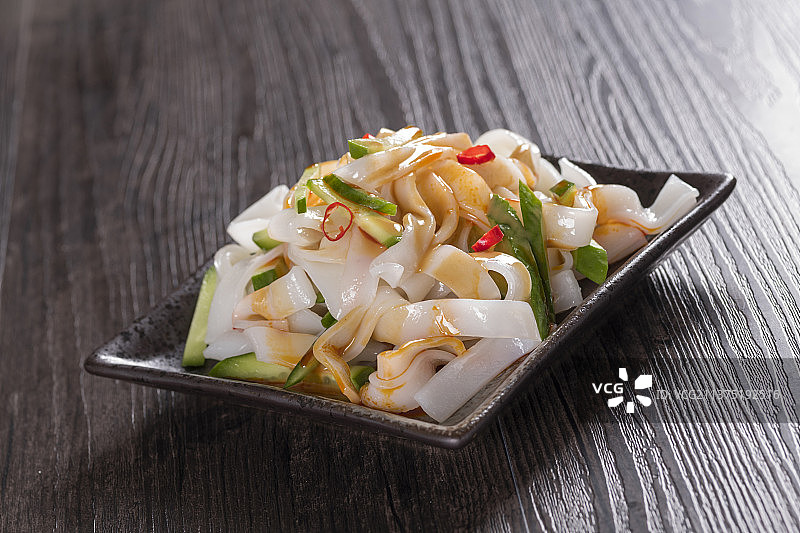 一盘拌凉皮与茶水摆放在桌面上图片素材