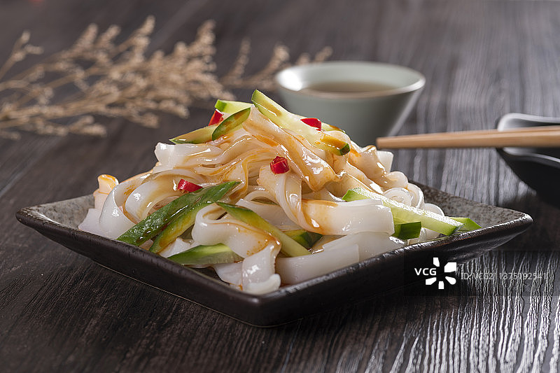 一盘拌凉皮与茶水摆放在桌面上图片素材