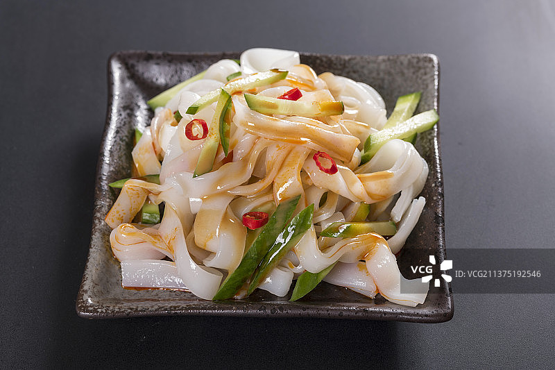 一盘拌凉皮与茶水摆放在桌面上图片素材