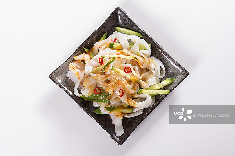 一盘拌凉皮与茶水摆放在桌面上图片素材