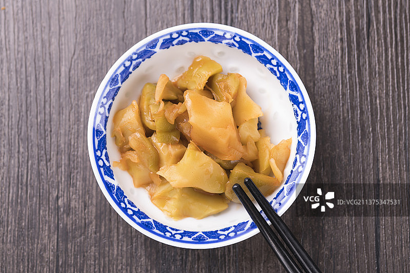 一盘榨菜摆放在木桌面上特写图片素材