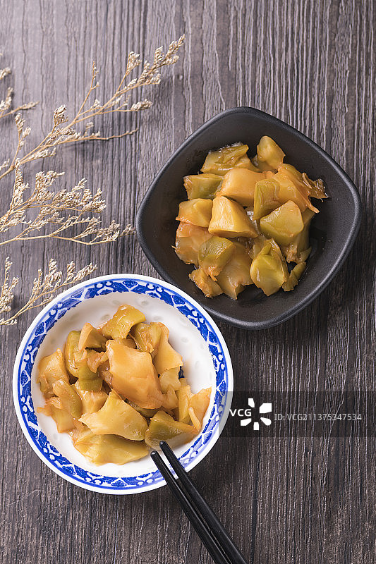一盘榨菜摆放在木桌面上特写图片素材