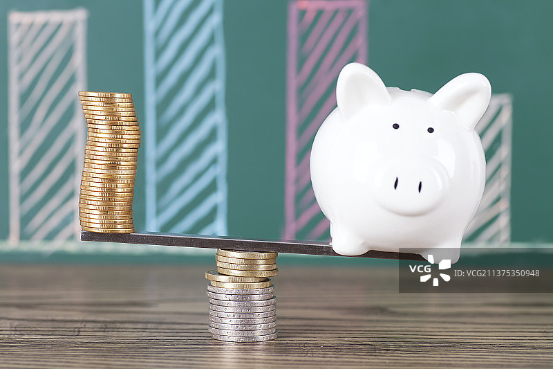 跷跷板上的硬币和存钱罐图片素材