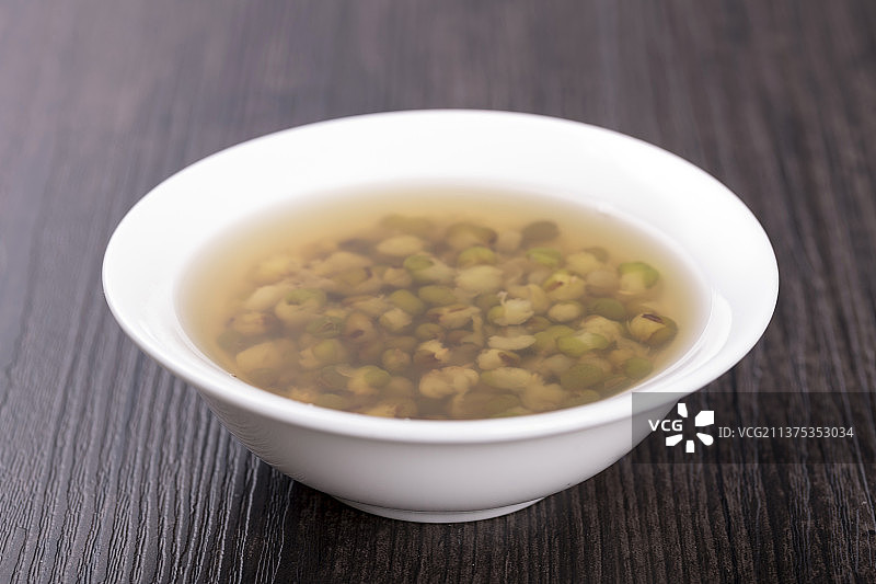 一碗绿豆汤与绿豆特写木桌面背景图片素材