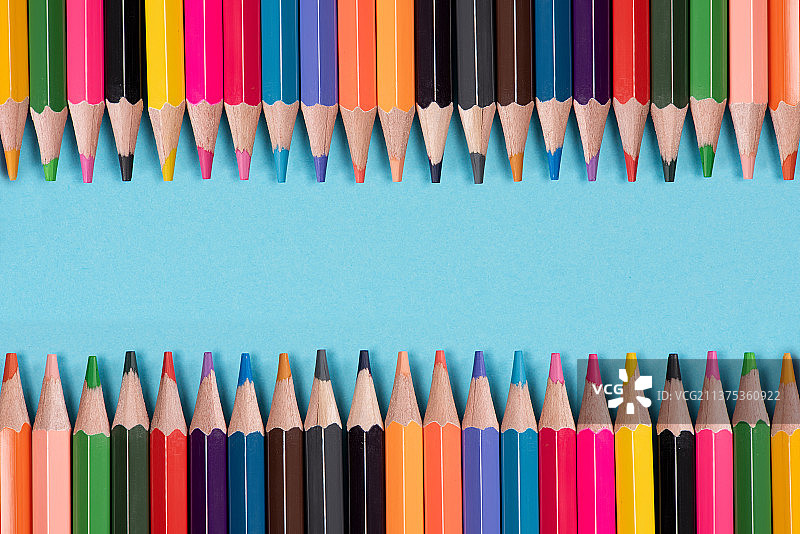 蓝色背景上排列的彩色铅笔图片素材