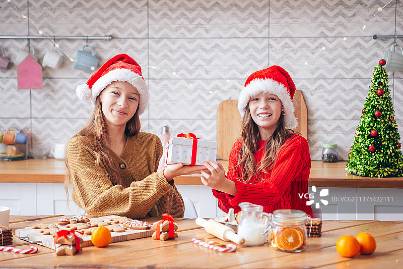 小女孩在家里的壁炉旁制作圣诞姜饼屋图片素材