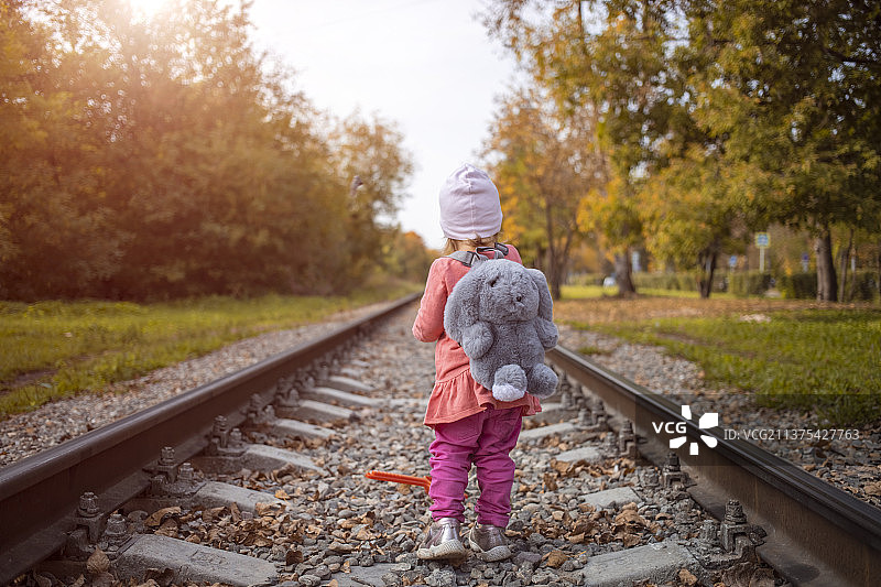 阳光明媚的夏日，儿童独自在铁轨上行走，危险图片素材