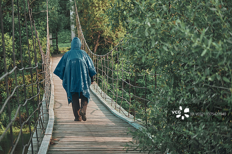穿蓝色雨衣徒步旅行的女孩图片素材