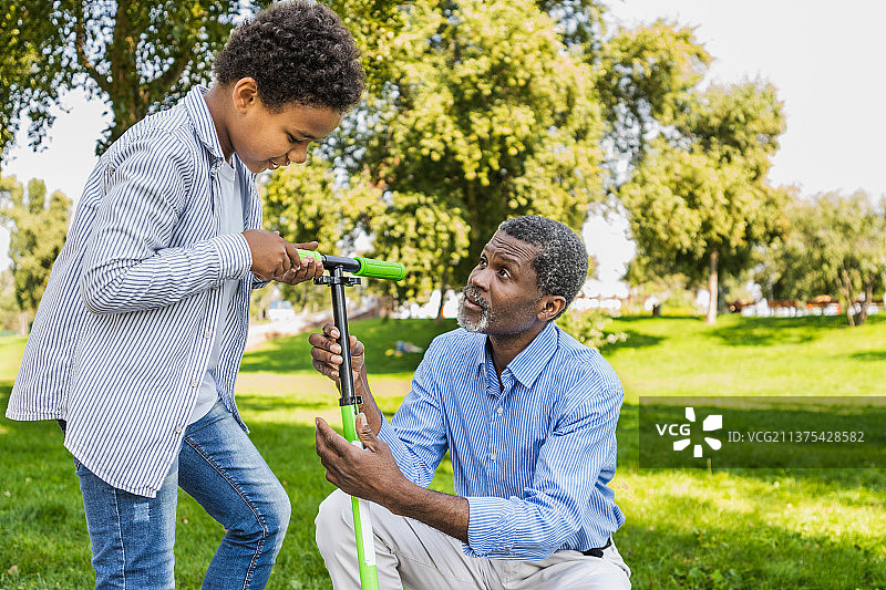 快乐的非裔美国家庭在公园里互动图片素材