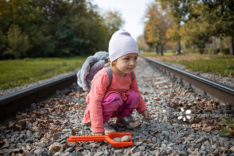 幼儿坐在铁轨上的危险情景图片素材