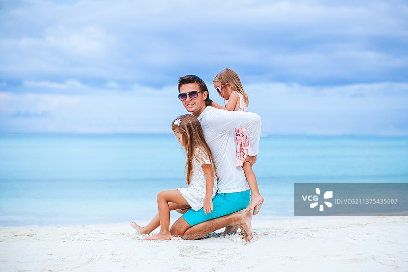 快乐美丽的家庭在热带海滩度假图片素材