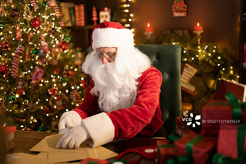 圣诞老人在办公桌前准备圣诞礼物图片素材