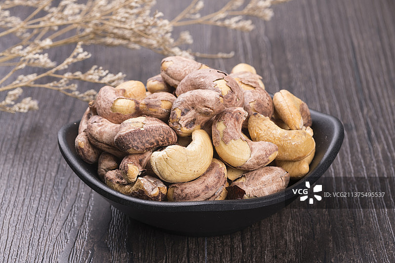 一盘腰果洋酒茶水摆放在桌面上特写图片素材