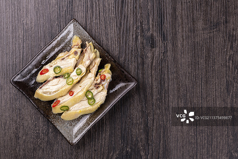 一盘椒麻鸡摆放在木桌面上特写图片素材