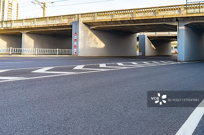 中国城市交通拍摄主题，一条弯曲平坦的马路，上方是火车道，下方是涵洞隧道，户外无人图像摄影图片素材
