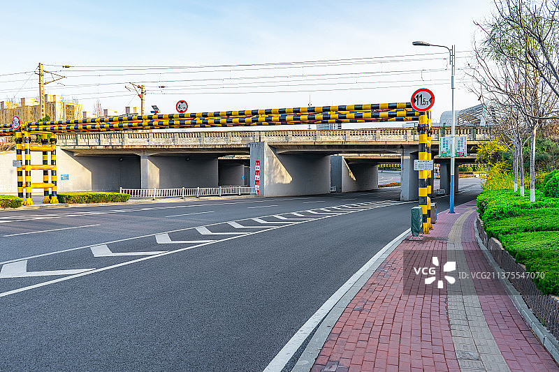 中国城市交通拍摄主题，一条弯曲平坦的马路，上方是火车道，下方是涵洞隧道，户外无人图像摄影图片素材