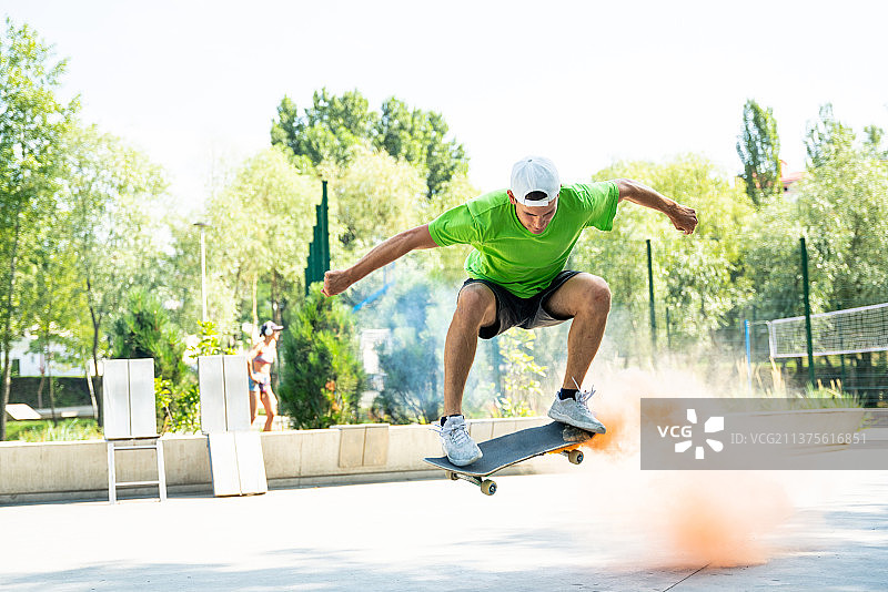 滑板者在公园的坡道上玩彩色烟雾弹图片素材