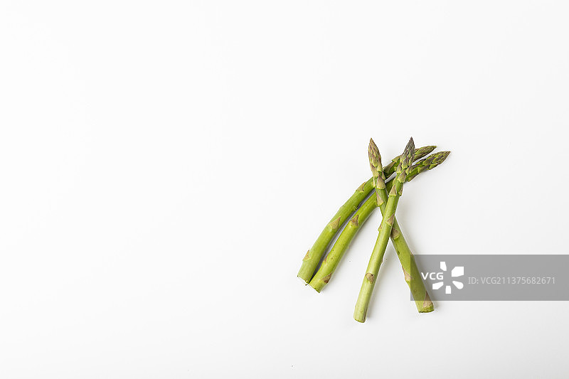 俯视视角下白色背景上的绿色生芦笋图片素材