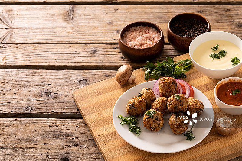 新鲜肉丸配调味料和蘸酱碗在木桌上的高角度视图图片素材