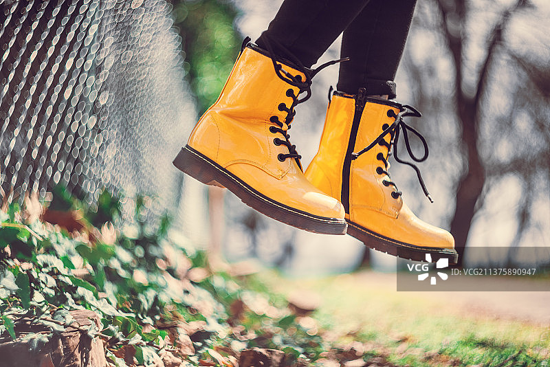 跳跃女孩的黄色靴子，老式镜头散景虚焦图片素材
